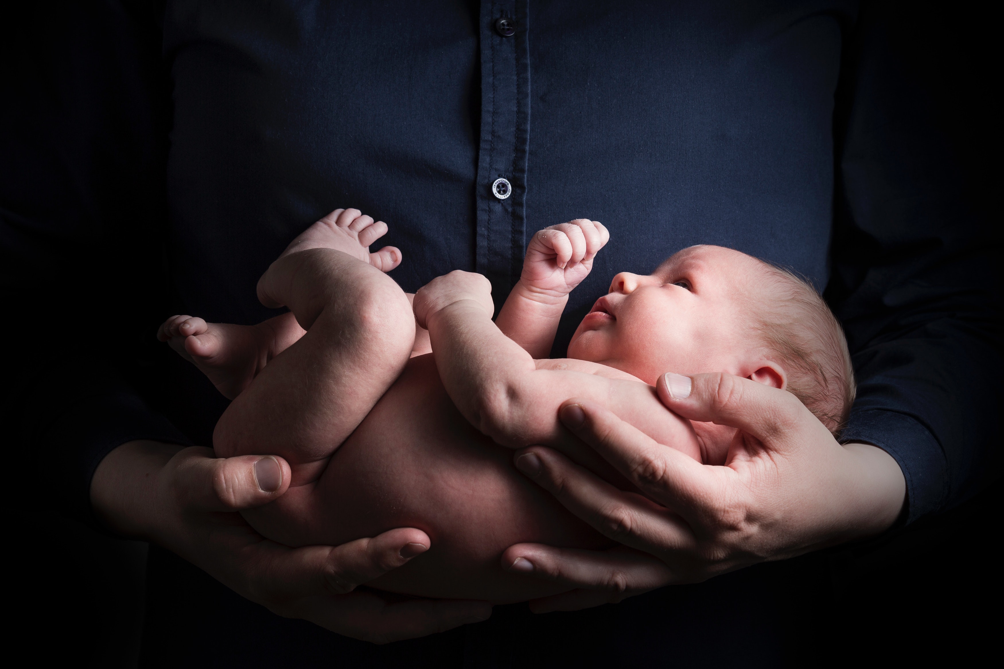close-up-photo-of-a-person-carrying-a-baby-2505110